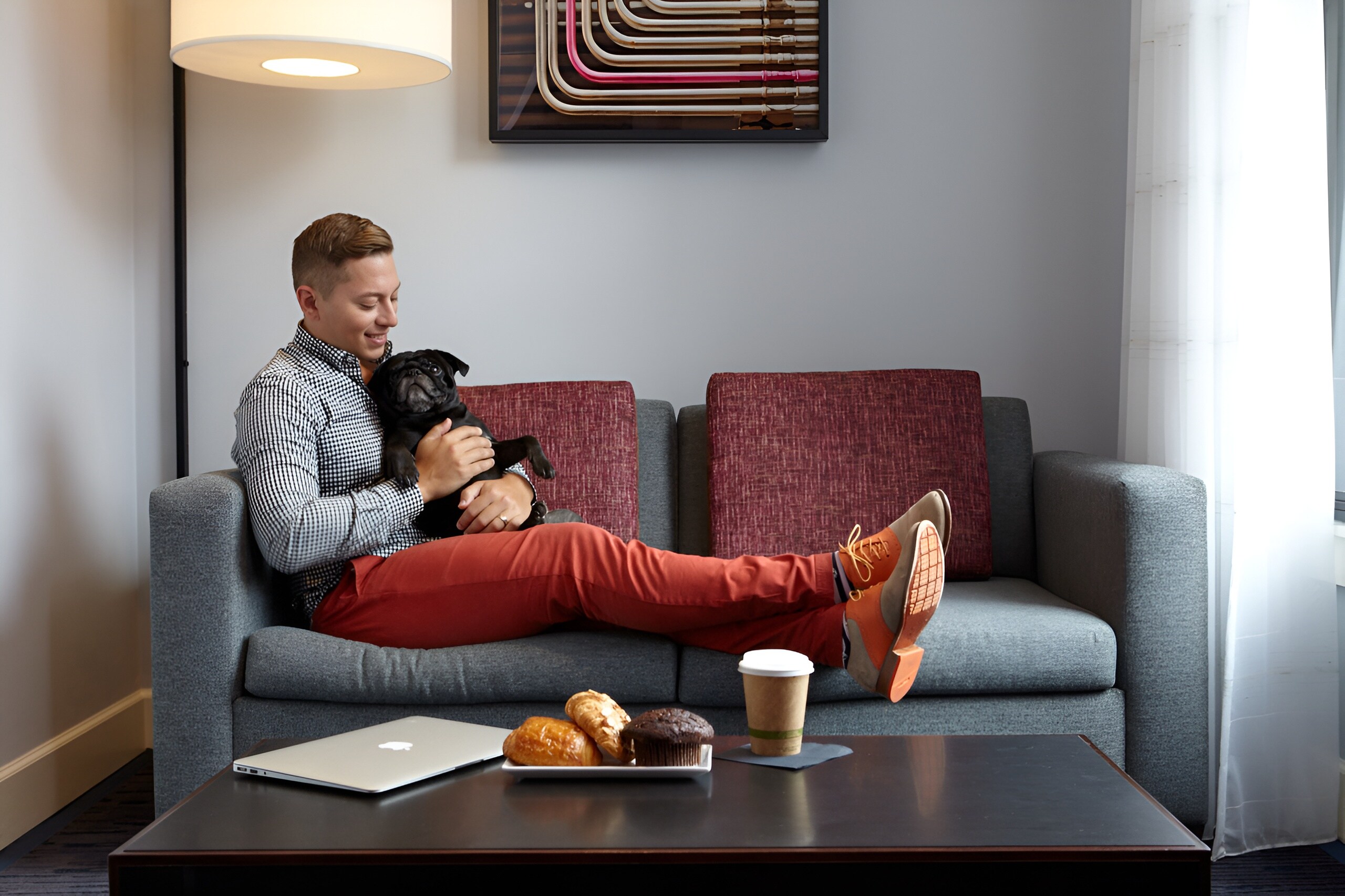 A guest relaxes with a dog in a cozy suite at Axiom Hotel, San Francisco.