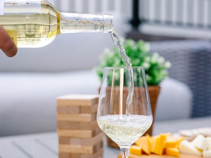 A person pouring white wine into a glass