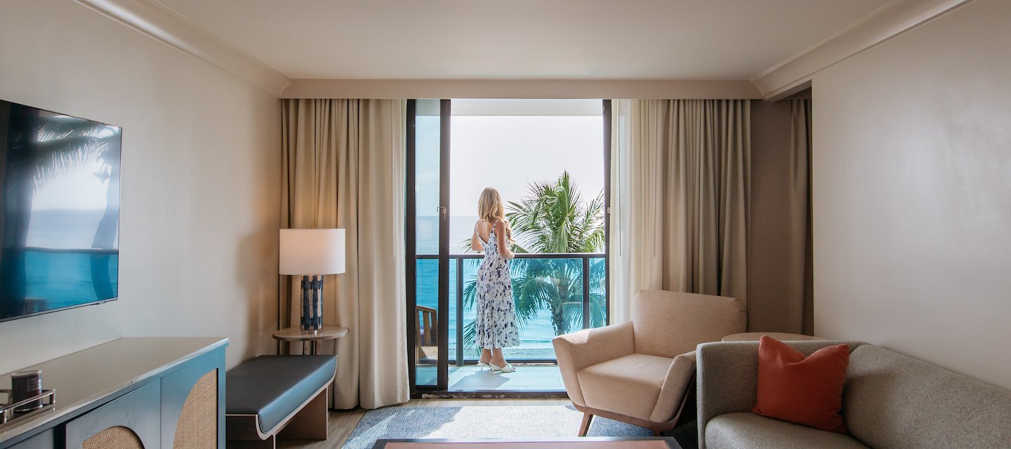 A guest enjoys ocean views from her room at Tideline Resort & Spa, Palm Beach, Florida