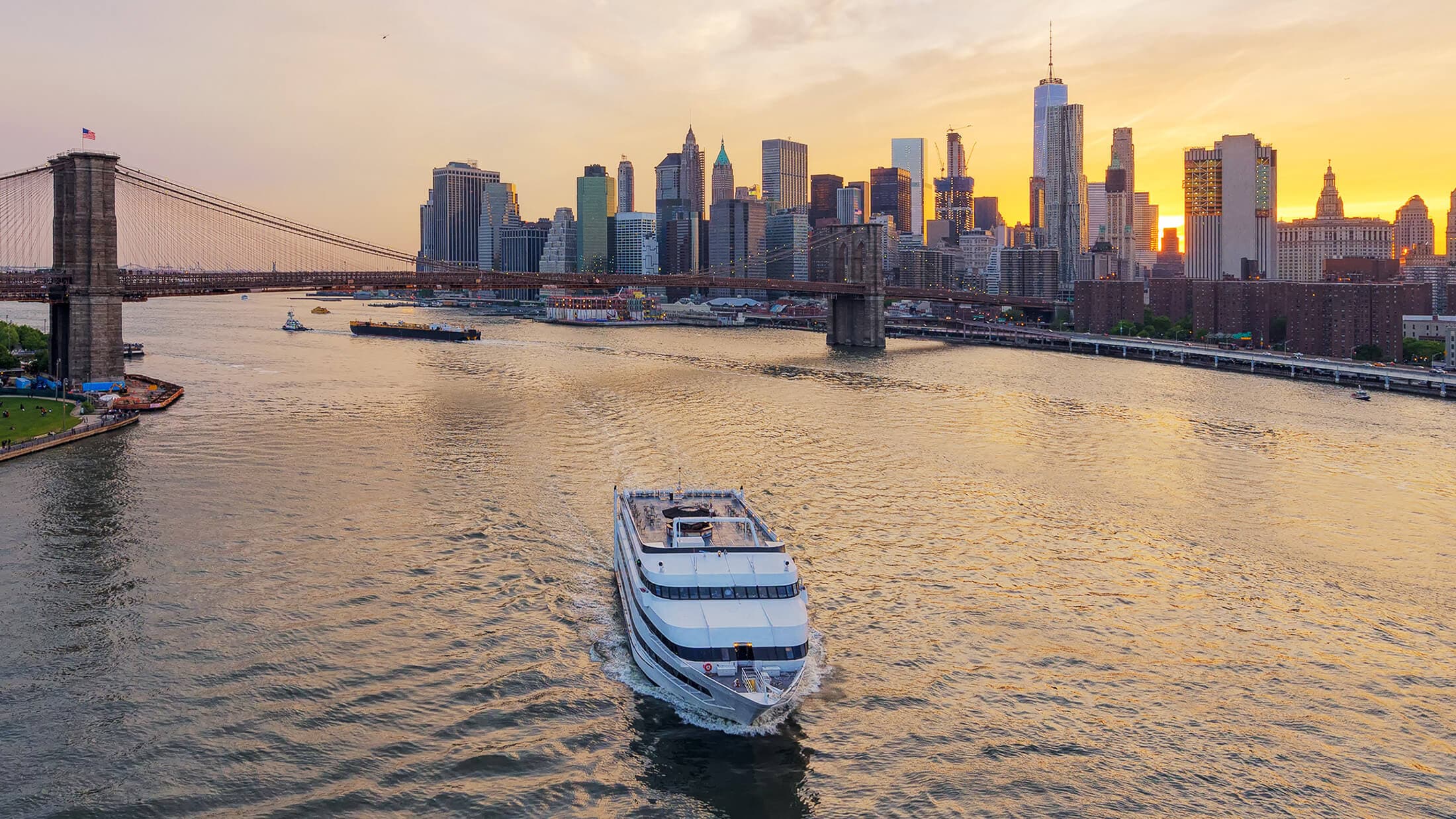 a large white boat on a river with a city skyline in the background