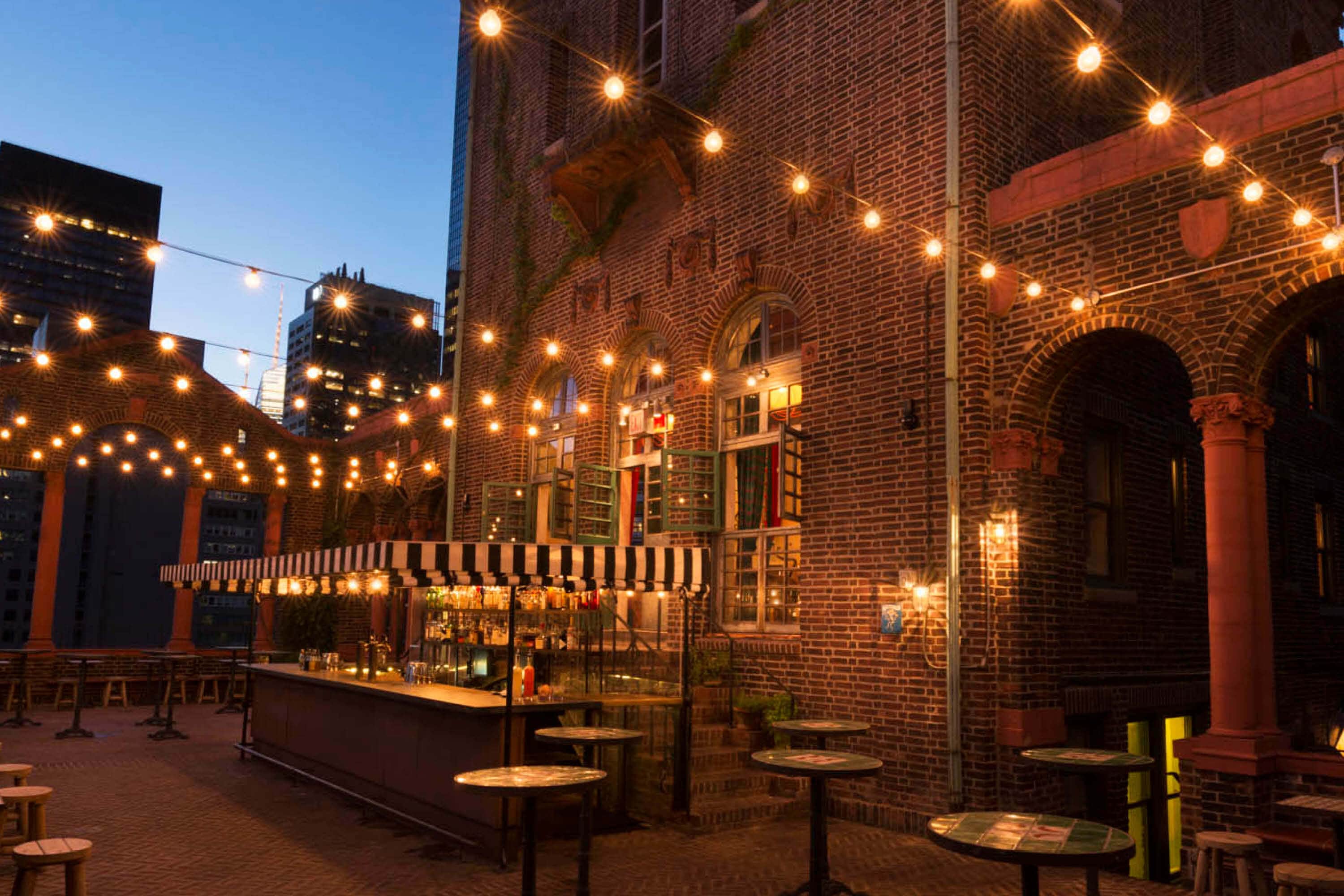 A brick building with a bar area and string lights