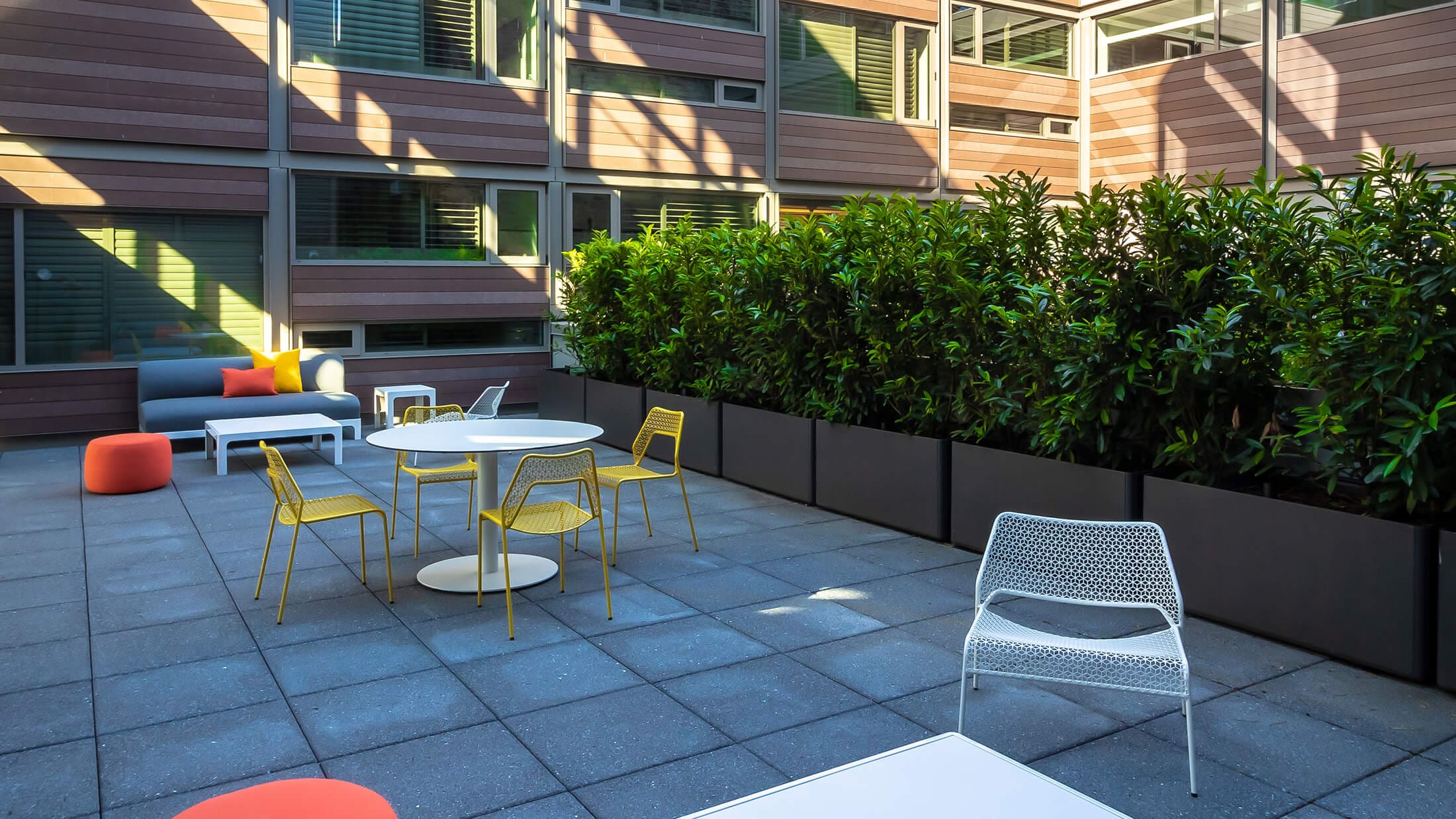 An outdoor seating area with furniture and planters in front of a building.