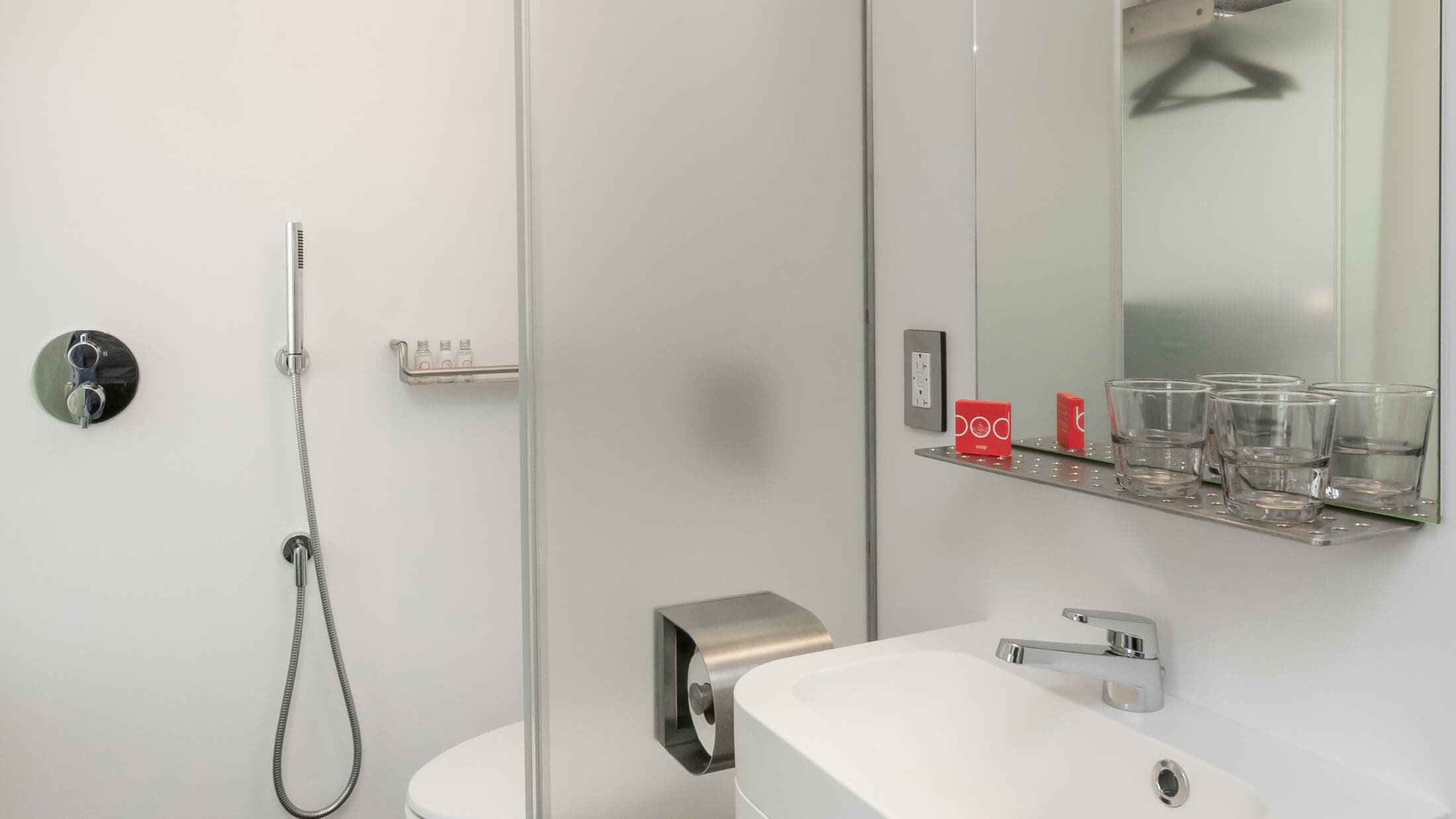 A modern bathroom with a white sink, toilet, and shower