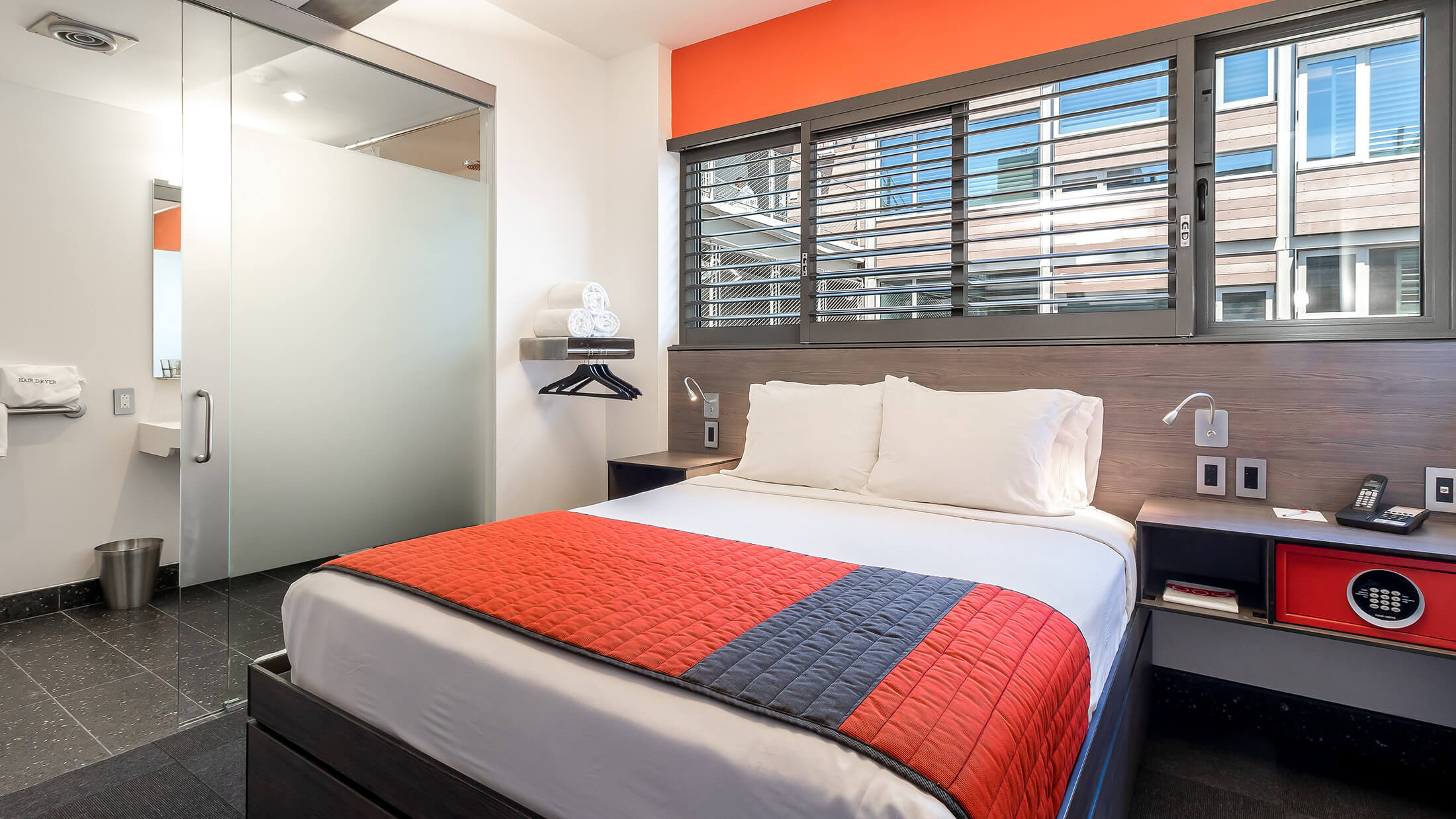 A hotel room with a bed, nightstands, and a closet