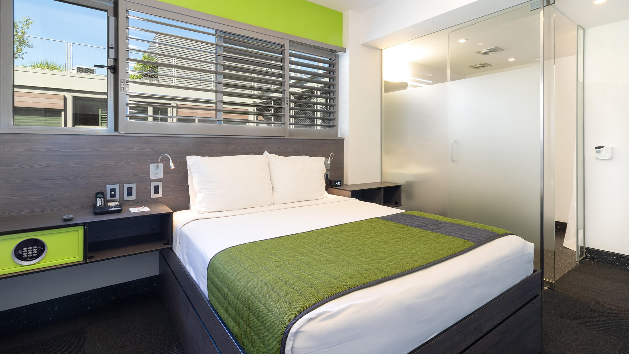 A hotel room with a bed, window, and desk.