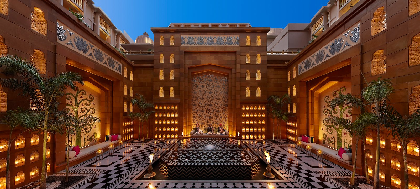 The Leela Palace Udaipur's opulent courtyard stuns guests with its detailed tilework and candlelit atmosphere.