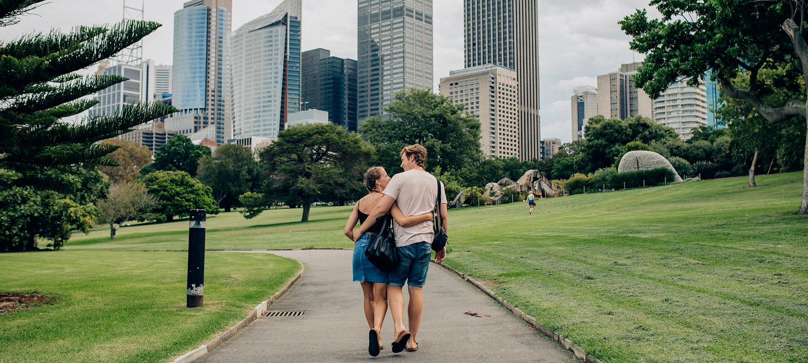 A couple strolling through Sydney's verdant botanical gardens.
