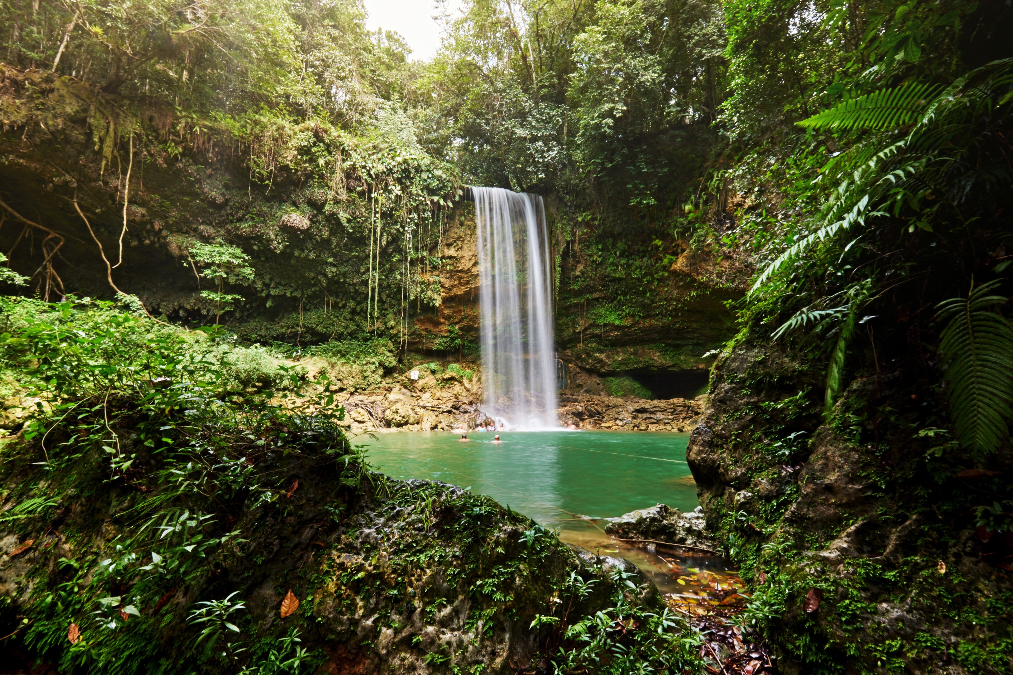 A waterfall 20 meters high, formed by the Socoa River in the Dominican Republic, spills into an aqua pool.