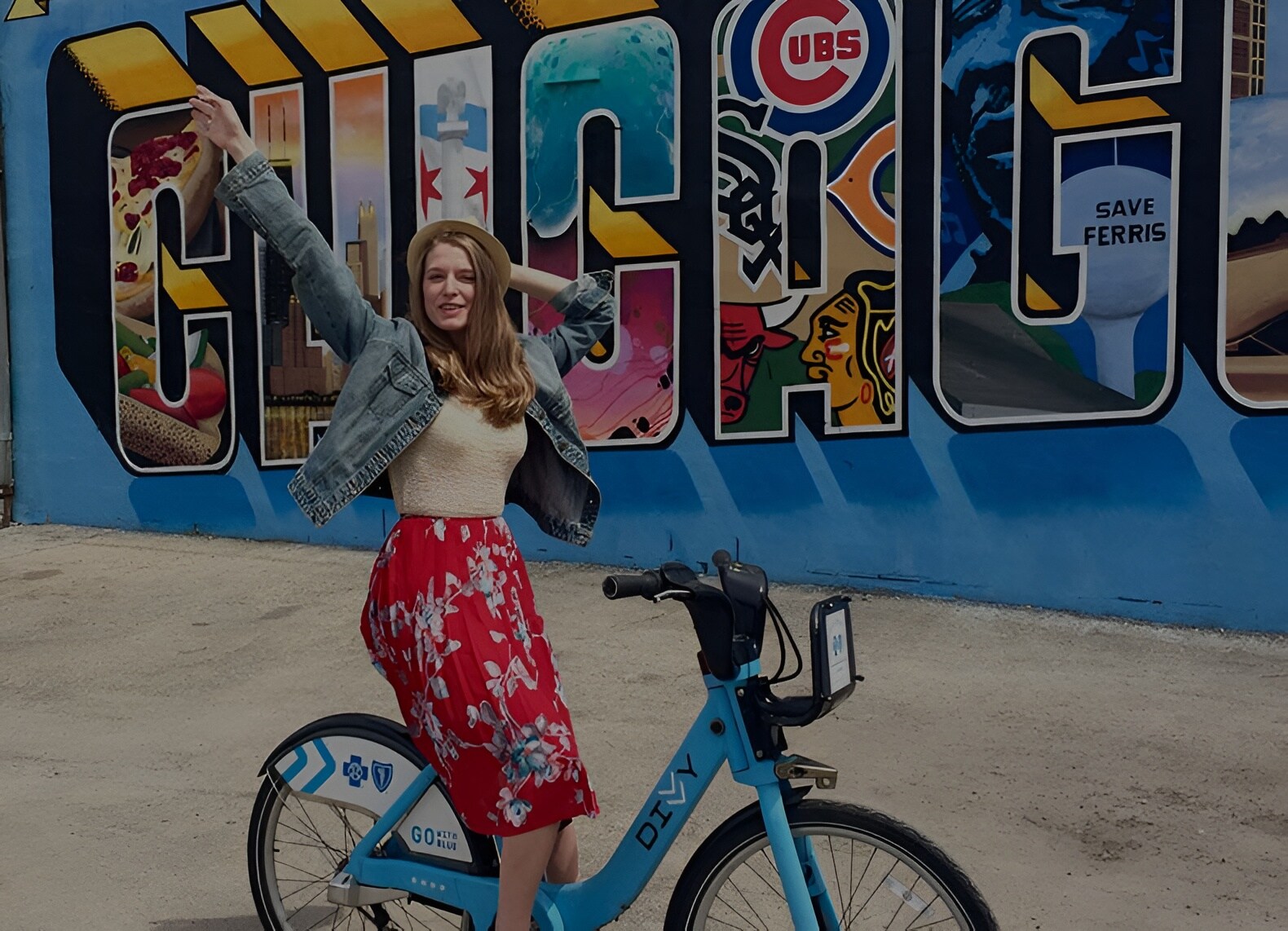 A young woman poses joyfully on a bike near ACME Hotel in Chicago.