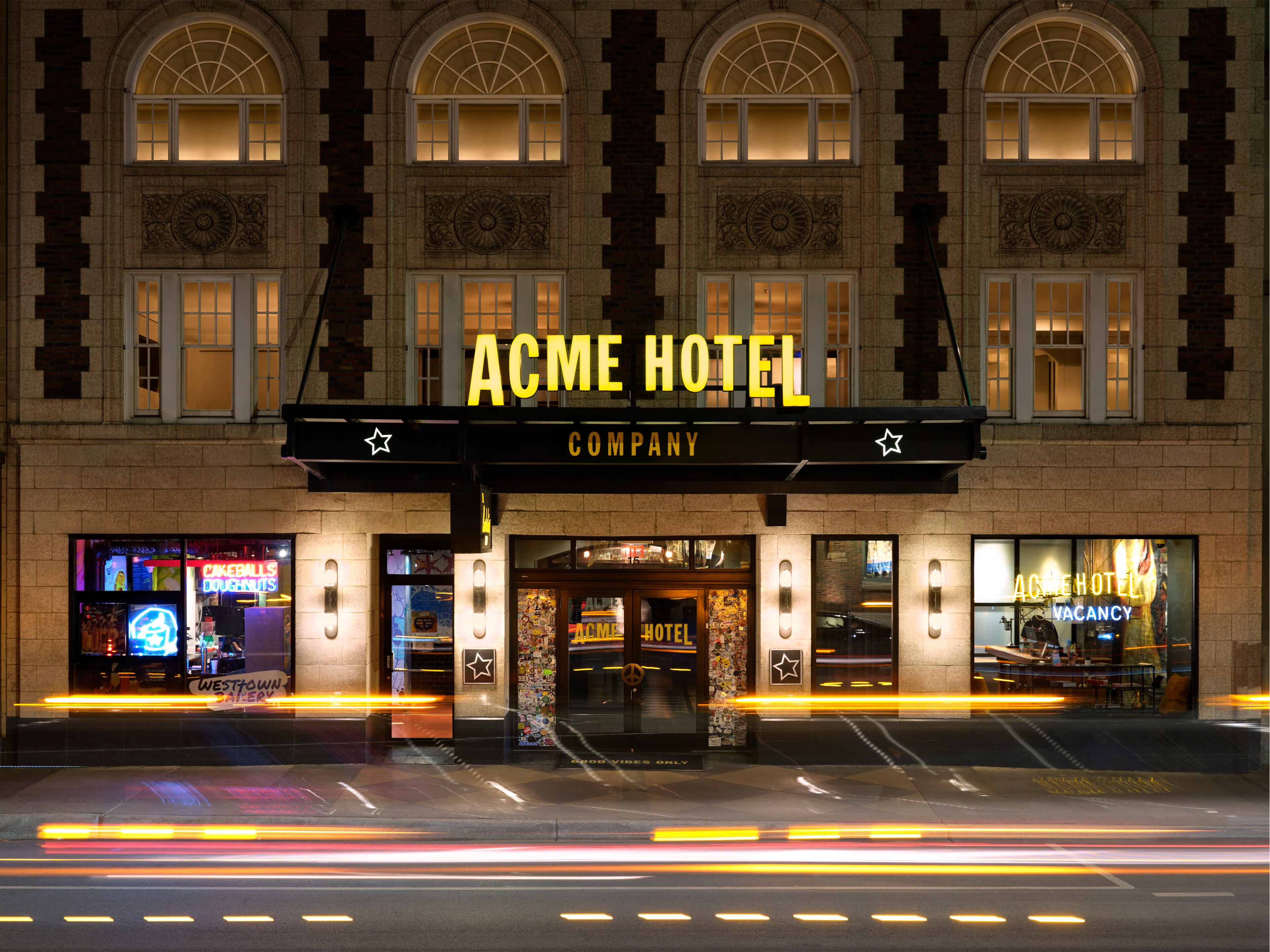 The ACME Hotel in Chicago showcases a vibrant, illuminated façade at night.