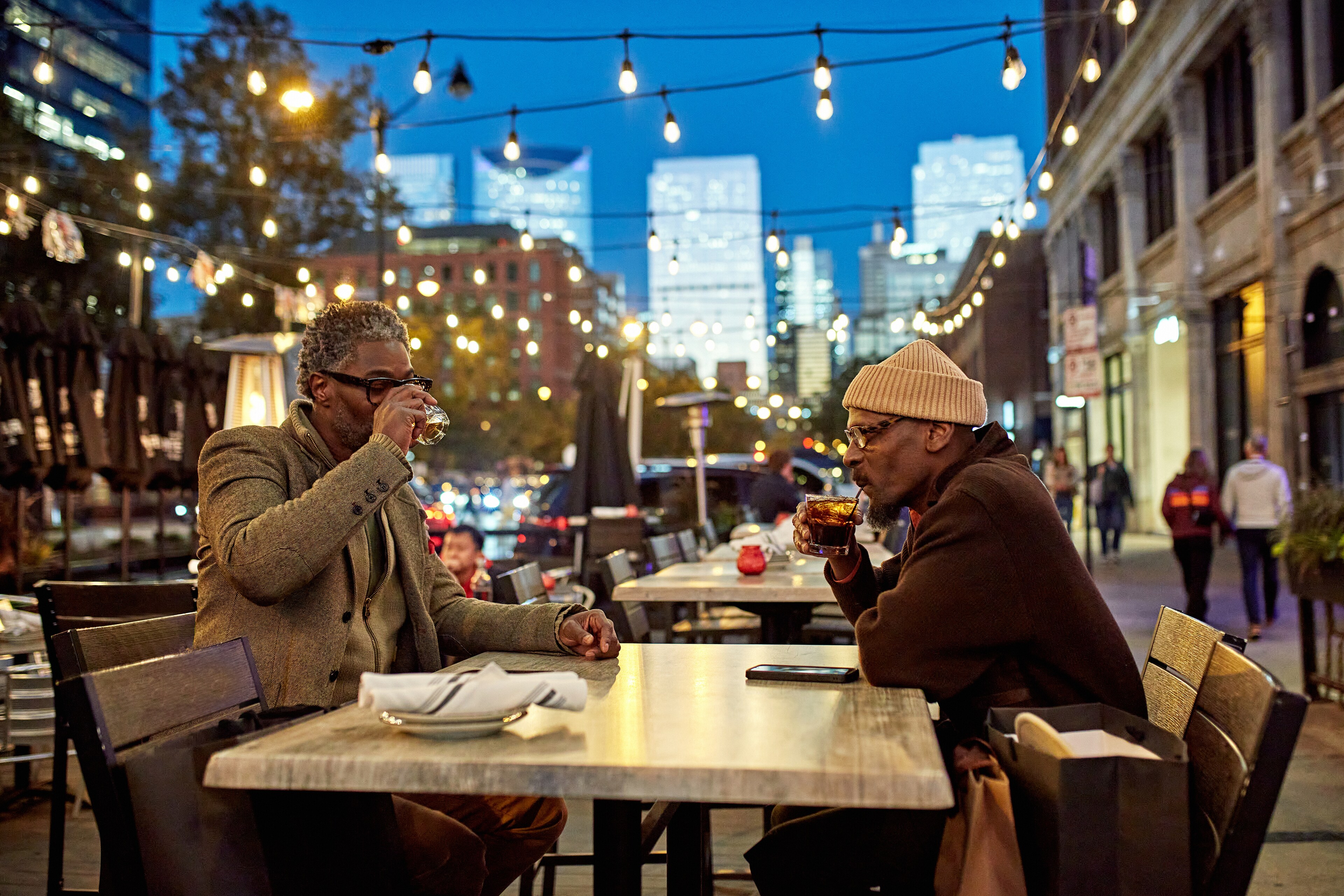 Two guests enjoy drinks at ACME Hotel's outdoor patio in Chicago.