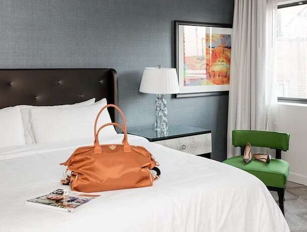 Suitcase on a king bed upon arrival at Melrose Georgetown Hotel