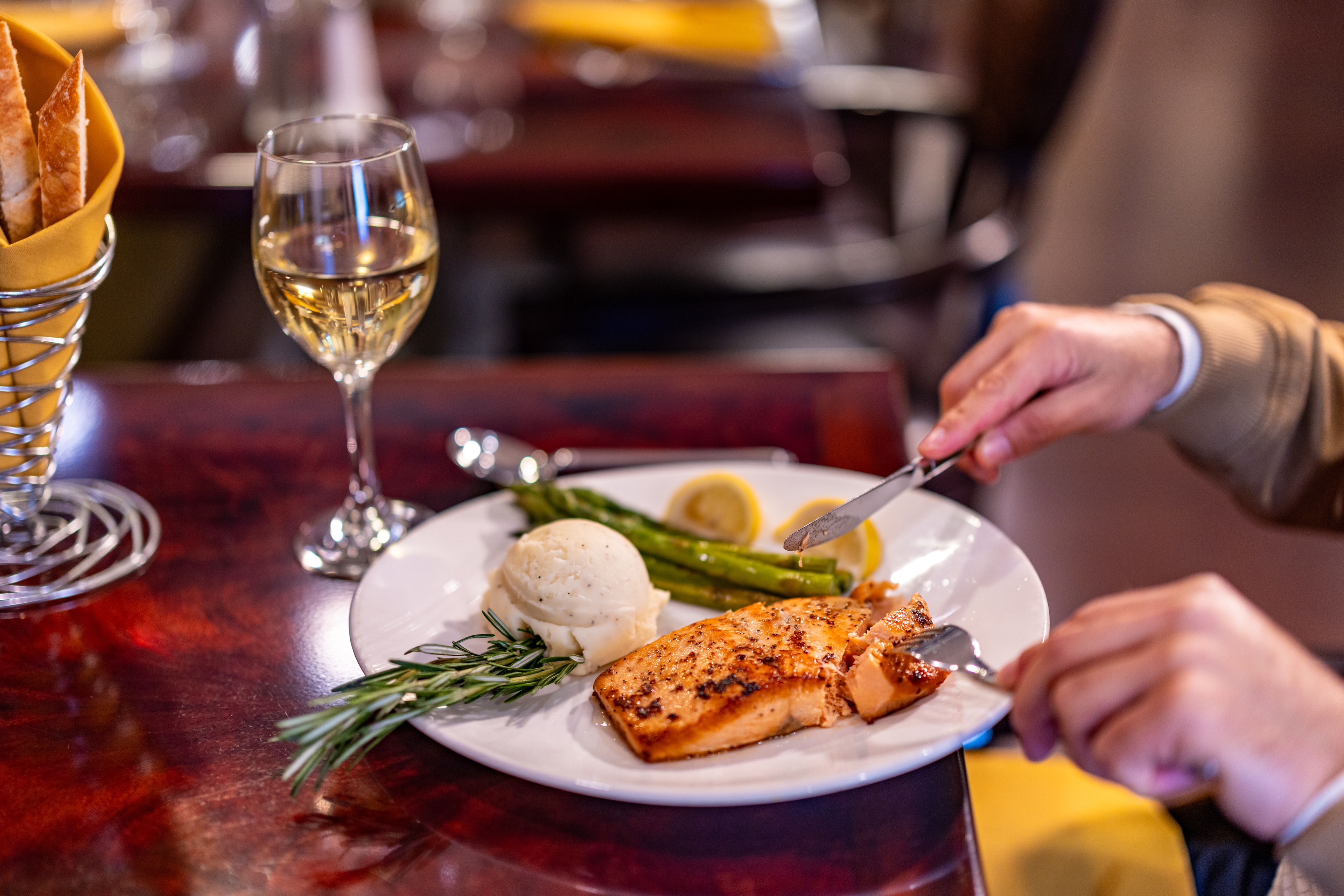 A plate of food with a glass of wine on a table.