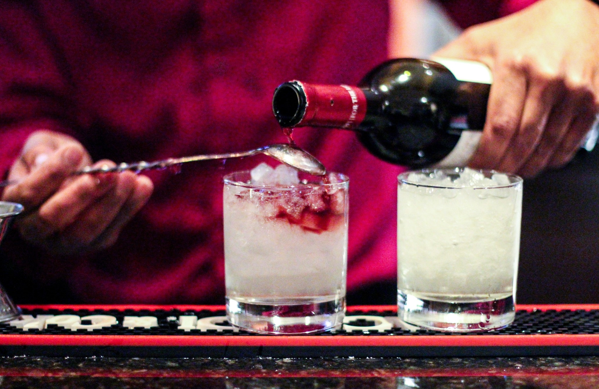 a bartender pouring a drink into a glass