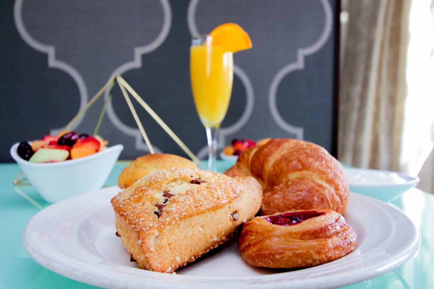 A plate of pastries and a glass of orange juice