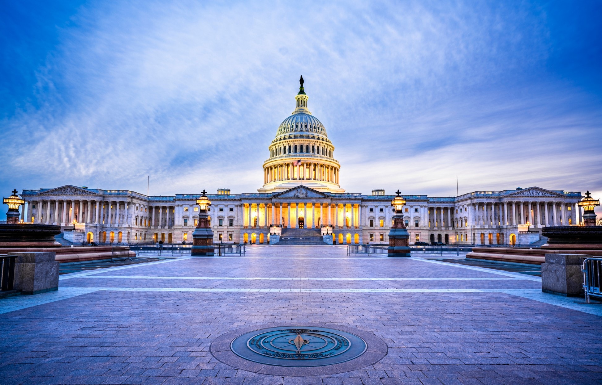 The US Capitol building at dusk with a blue sky and clouds