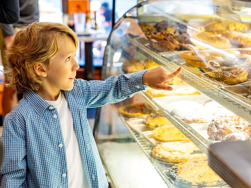 Child picking out a sweet treat at a local bakery
