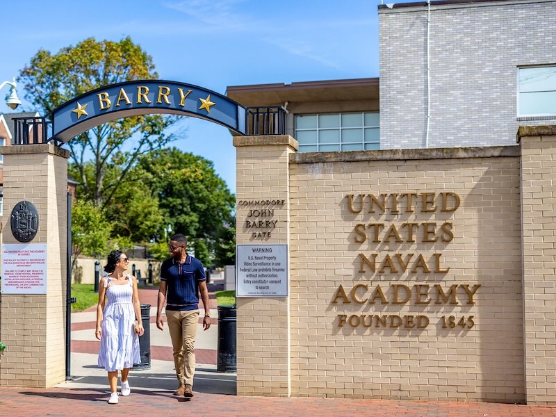 Two people walking through Barry Gate at the United States Naval Academy