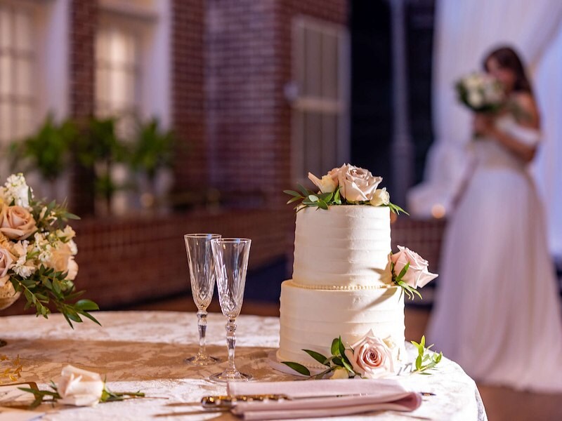 Elegant wedding cake with blush roses and champagne flutes at Historic Inns of Annapolis venue.