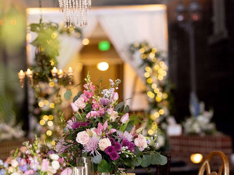 Romantic wedding reception table with floral arrangements and chandelier lighting in a courtyard at Historic Inns of Annapolis