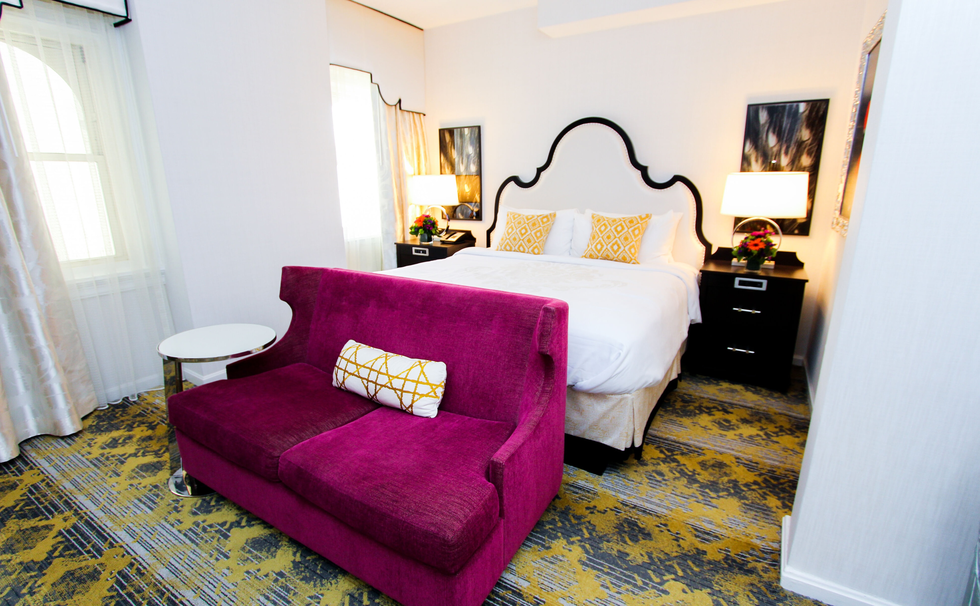 A hotel room with a bed, chair, and nightstand.