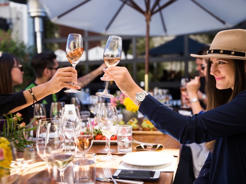 A group of people holding wine glasses