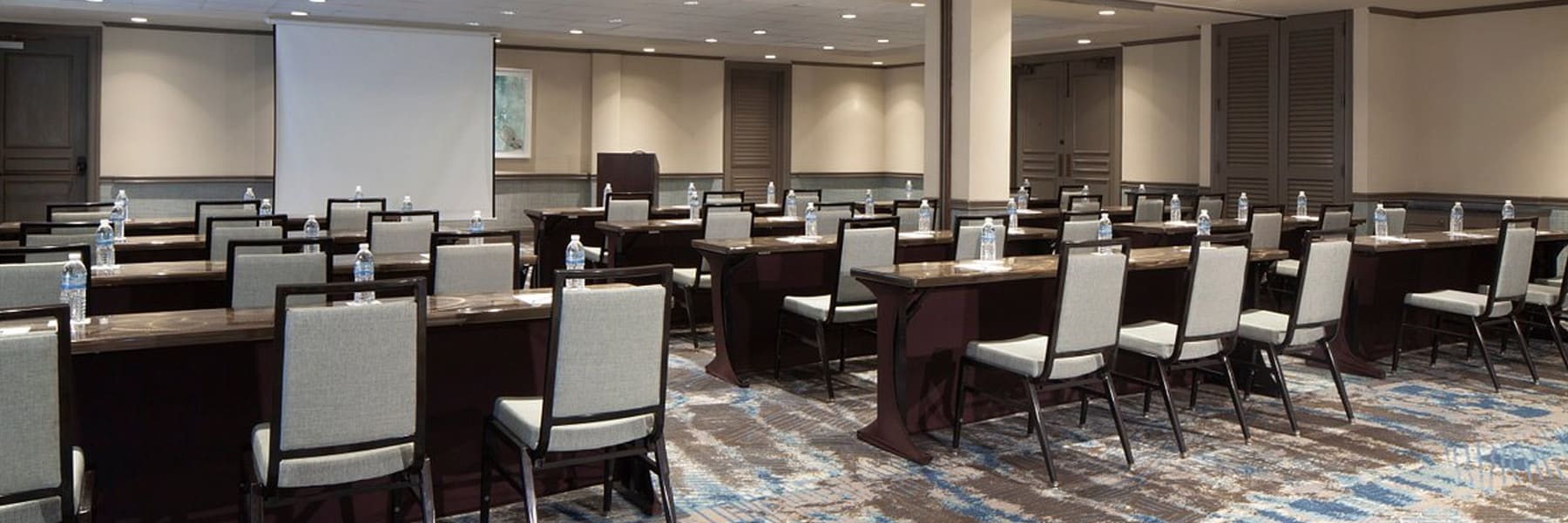 A wide view of a conference room with rows of tables and chairs.