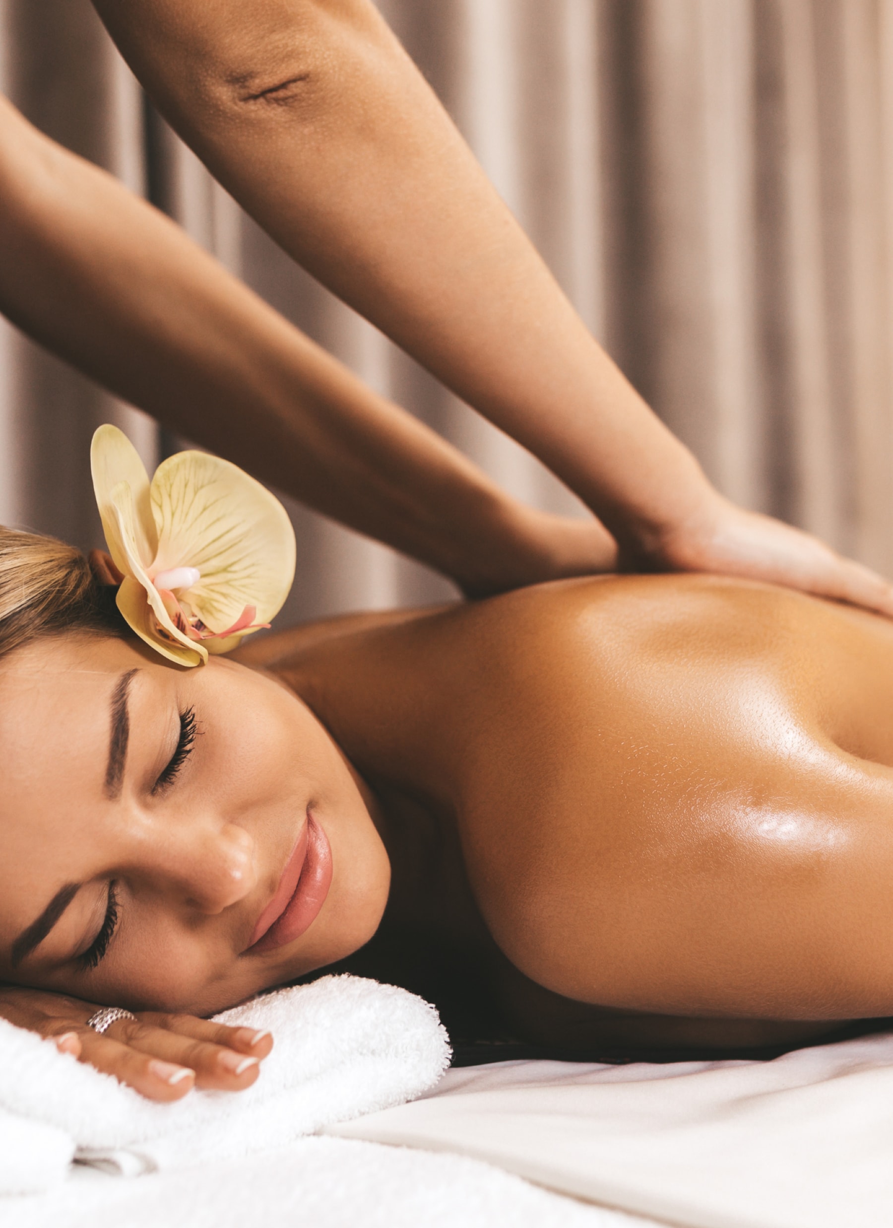 A woman receiving a massage with a flower on her head