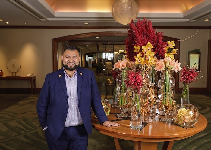 A man standing next to a table with flowers