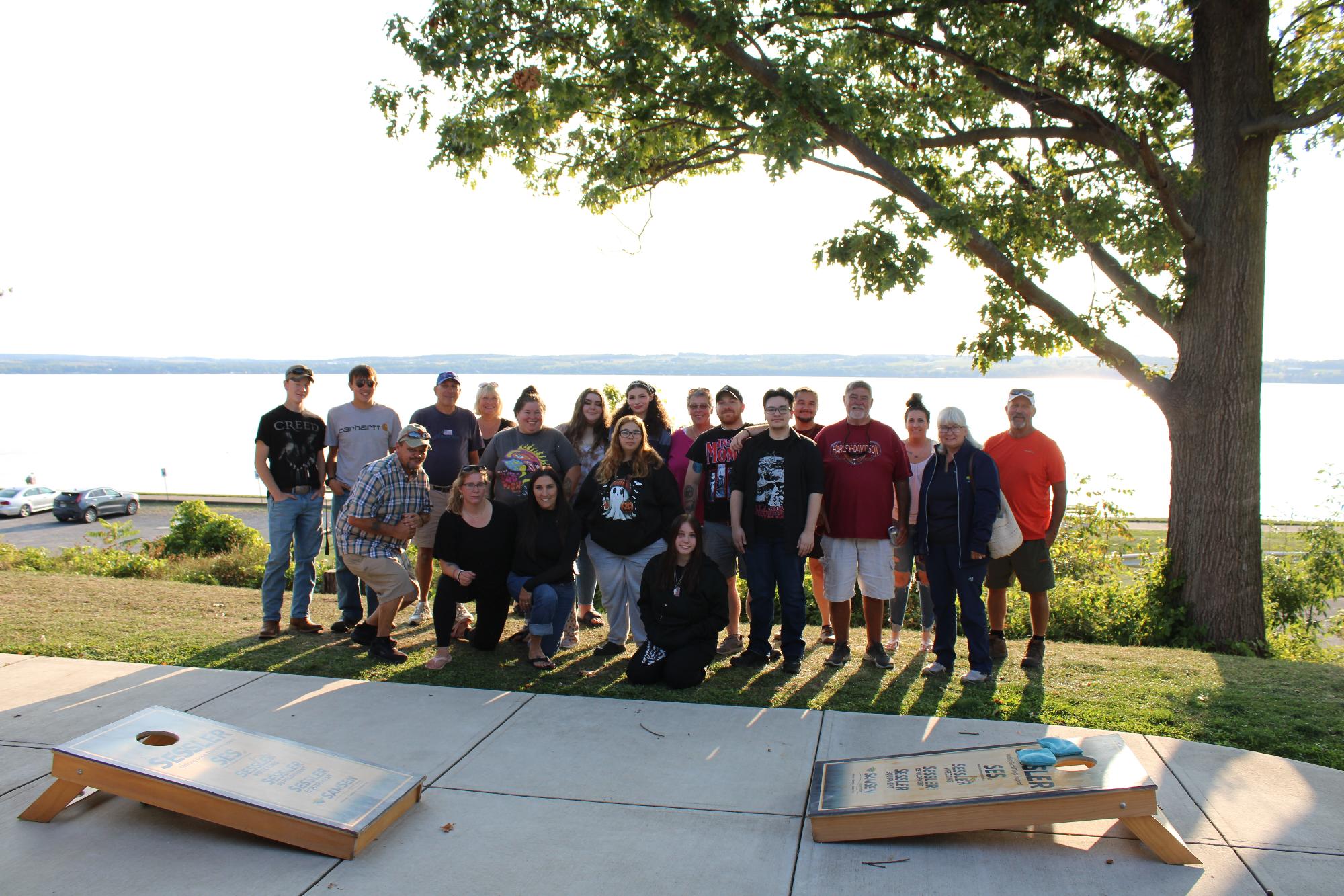 A group poses outdoors at Seneca Lake Resorts, enjoying the scenic lake view.