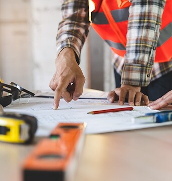A man standing at a table with construction plans