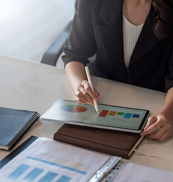 A woman in a business suit is working on a tablet