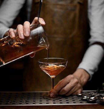 Bartender pouring a drink into a glass