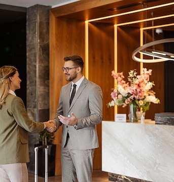 A man and woman are standing at the front desk