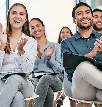 A group of people clapping in a meeting