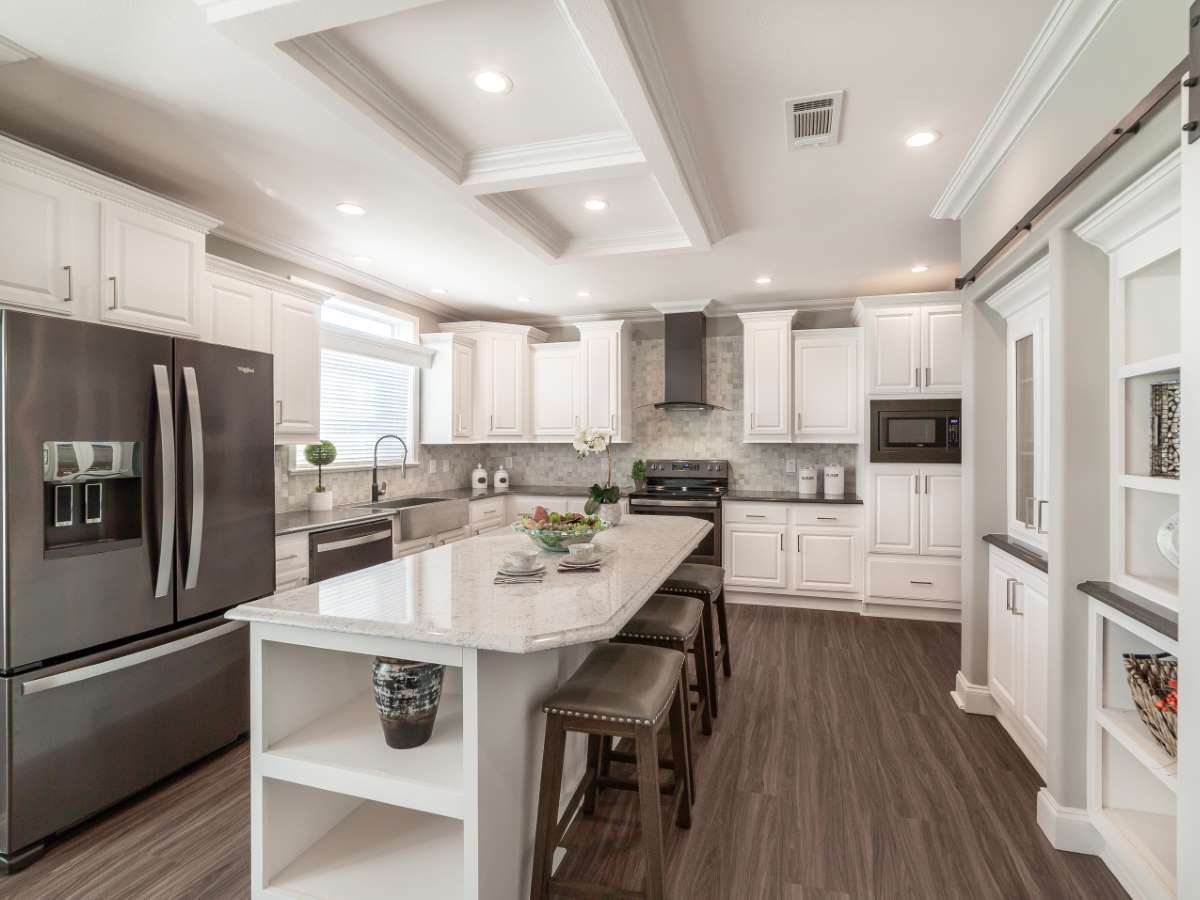A kitchen with white cabinets and a large island