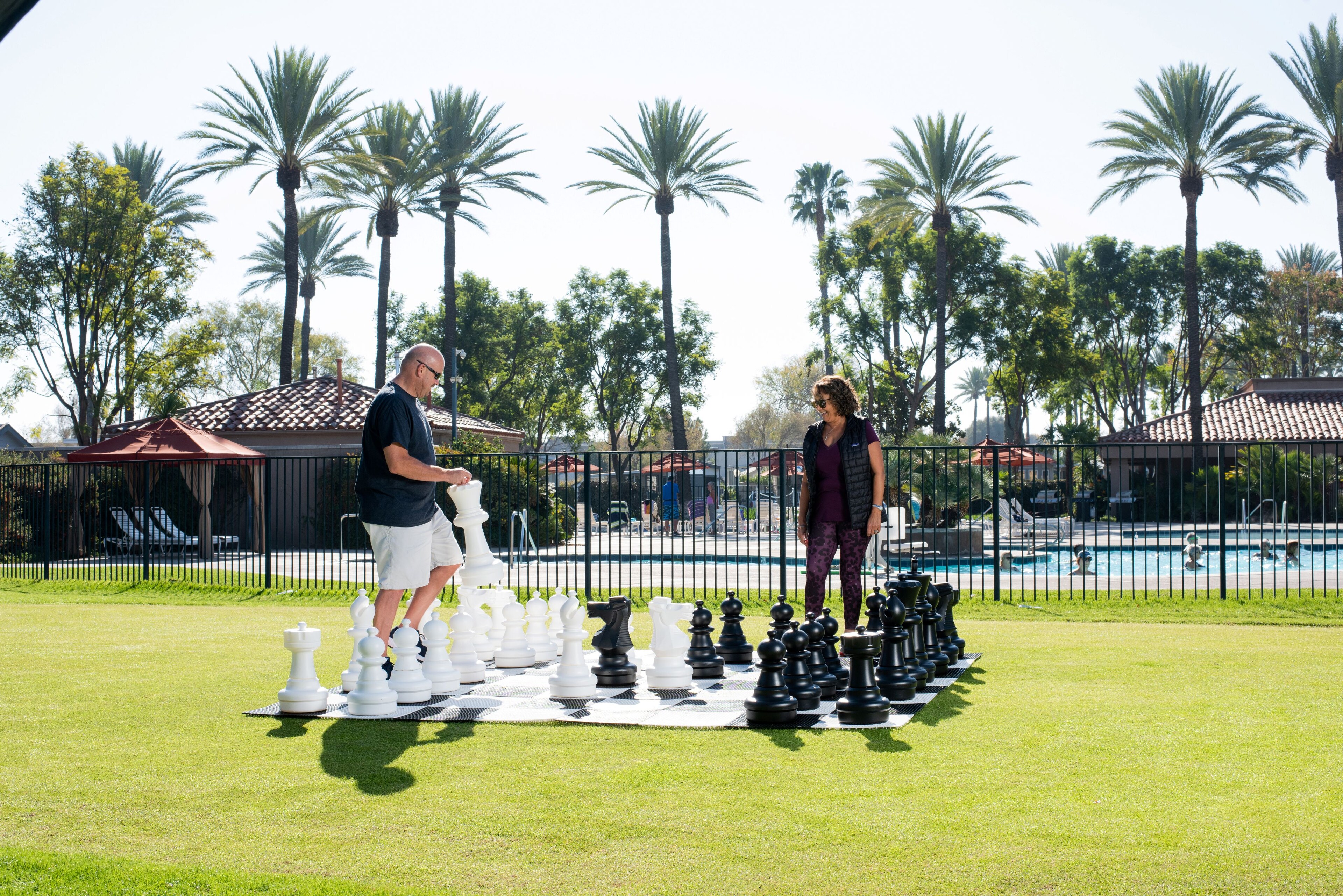 Stay, Play, Relax man and woman engaged in a chess game at Golden Village Palms RV Resort - Hemet California