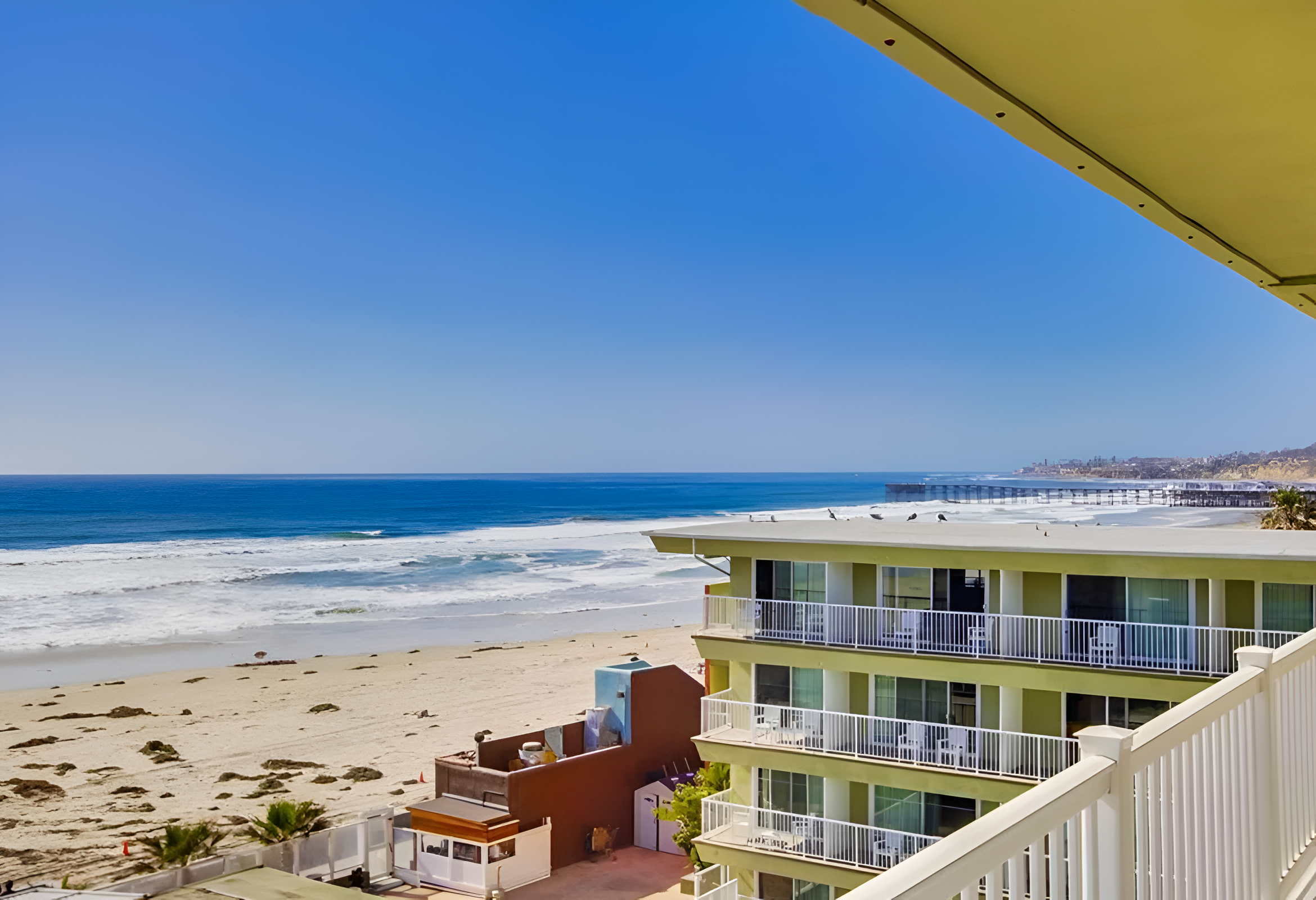 A beachfront building with balconies overlooking the ocean.