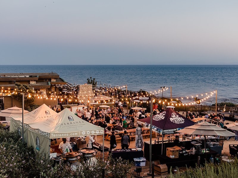 A large outdoor event with tents and lights