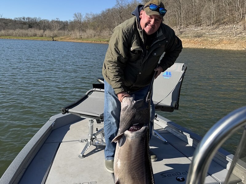 Angler holding two crappie caught in the Ozarks during spring fishing season