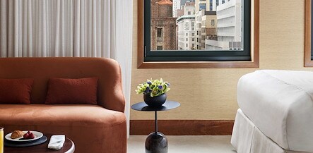 A hotel room with a bed, couch and a window, The Kitano Hotel New York