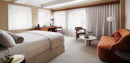 A hotel room with a bed, couch and a window, The Kitano Hotel New York