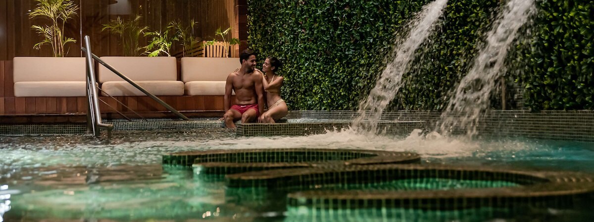 Una pareja se relaja en una piscina en The Reef Resorts en Playa Del Carmen, México.