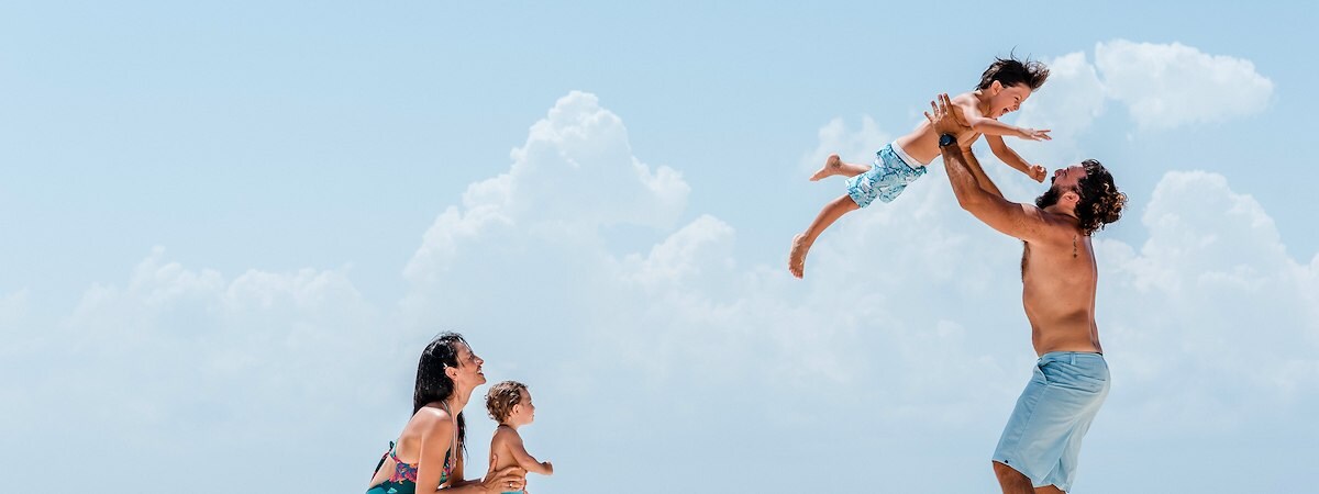 A family enjoys quality time on the beach at The Reef Resorts in Playa Del