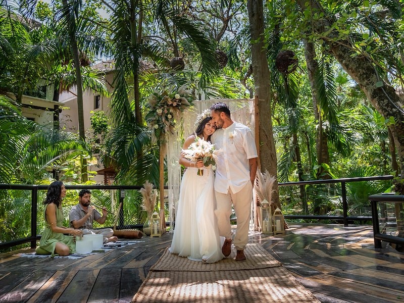 A man and woman in white dresses walking on a wooden platform