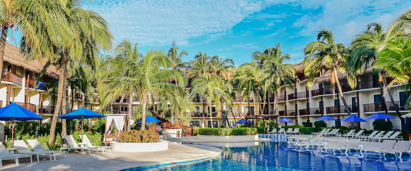 Relax by the pool at The Reef Coco Beach Resort & Spa in Playa Del Carmen.