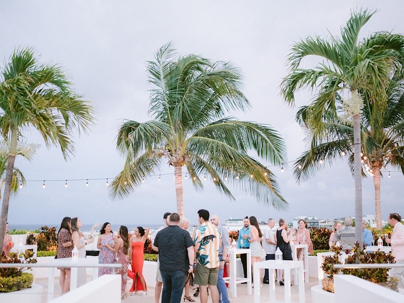 A group of people standing around a palm tree