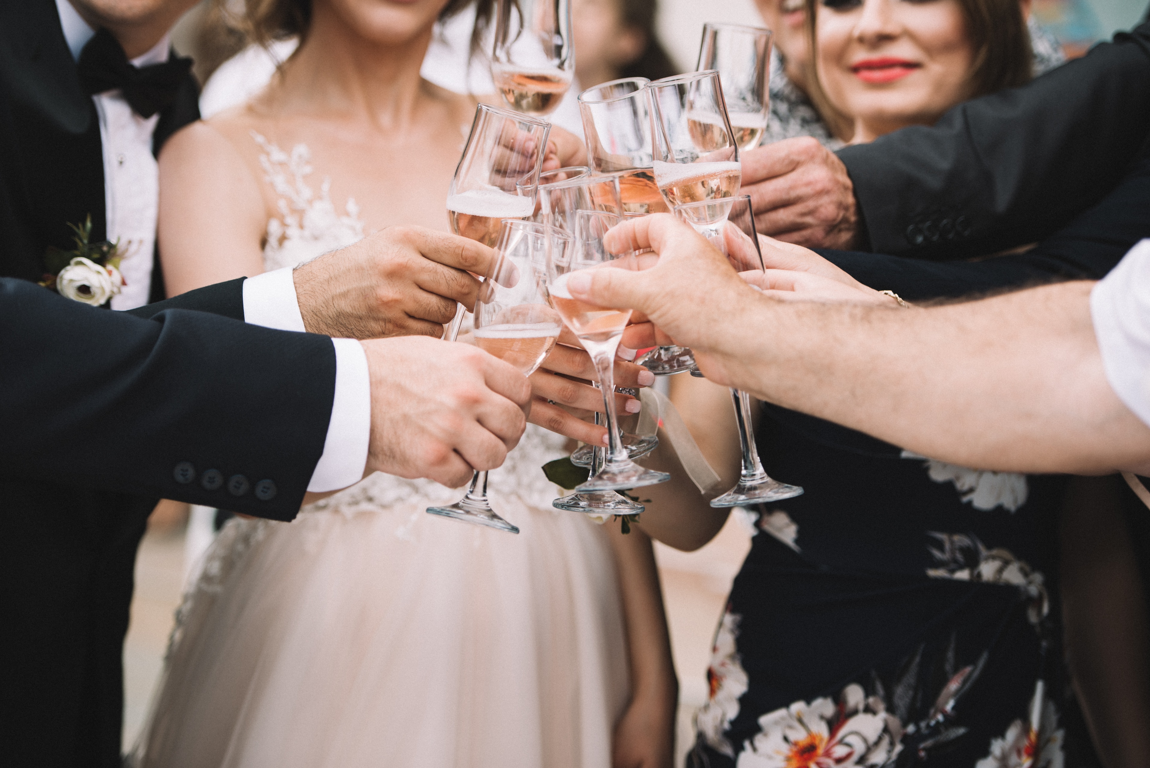 Wedding guests clinking glasses of rosé champagne in a celebratory toast at Texas