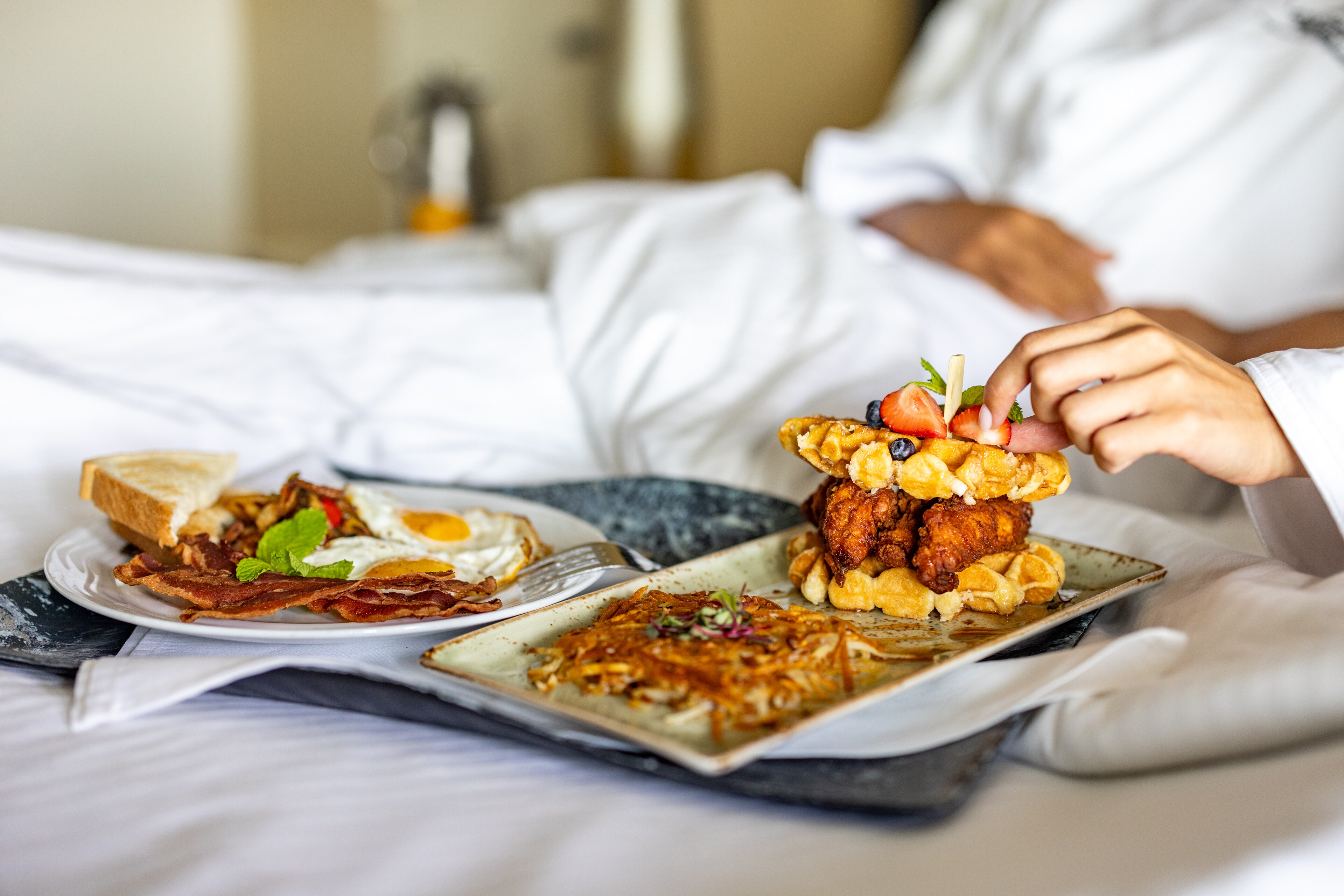 Person in a robe enjoys breakfast in bed at Lakeway Resort & Spa, Texas