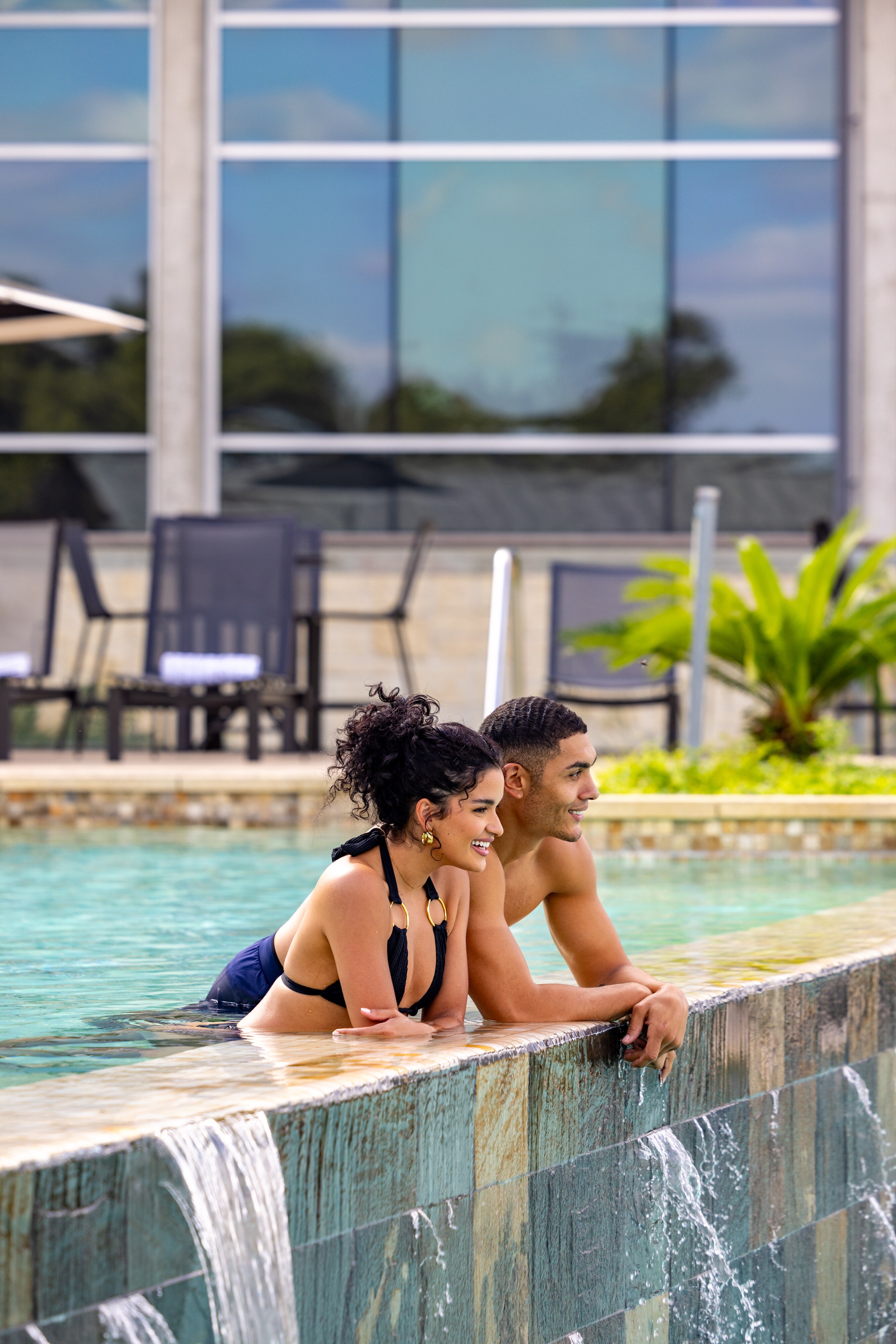 Couple relaxing and smiling at the edge of an infinity pool Lakeway Resort & Spa, Texas